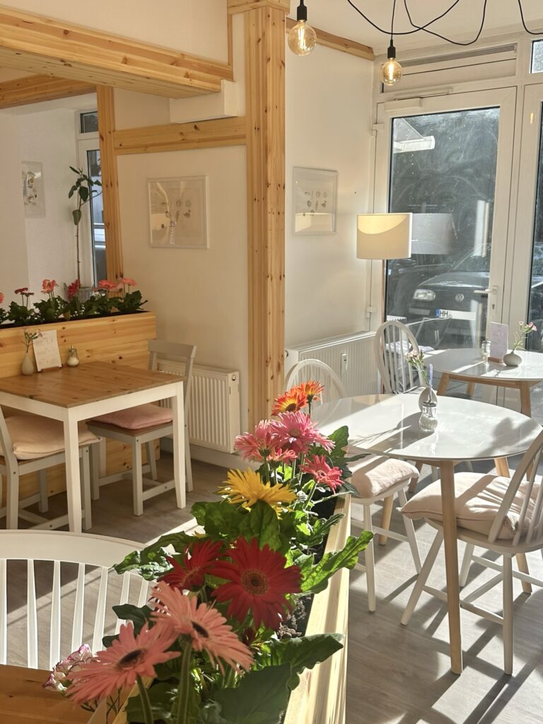 Cafe BiBimBox von innen mit Blumen und weiß+hellholz interior